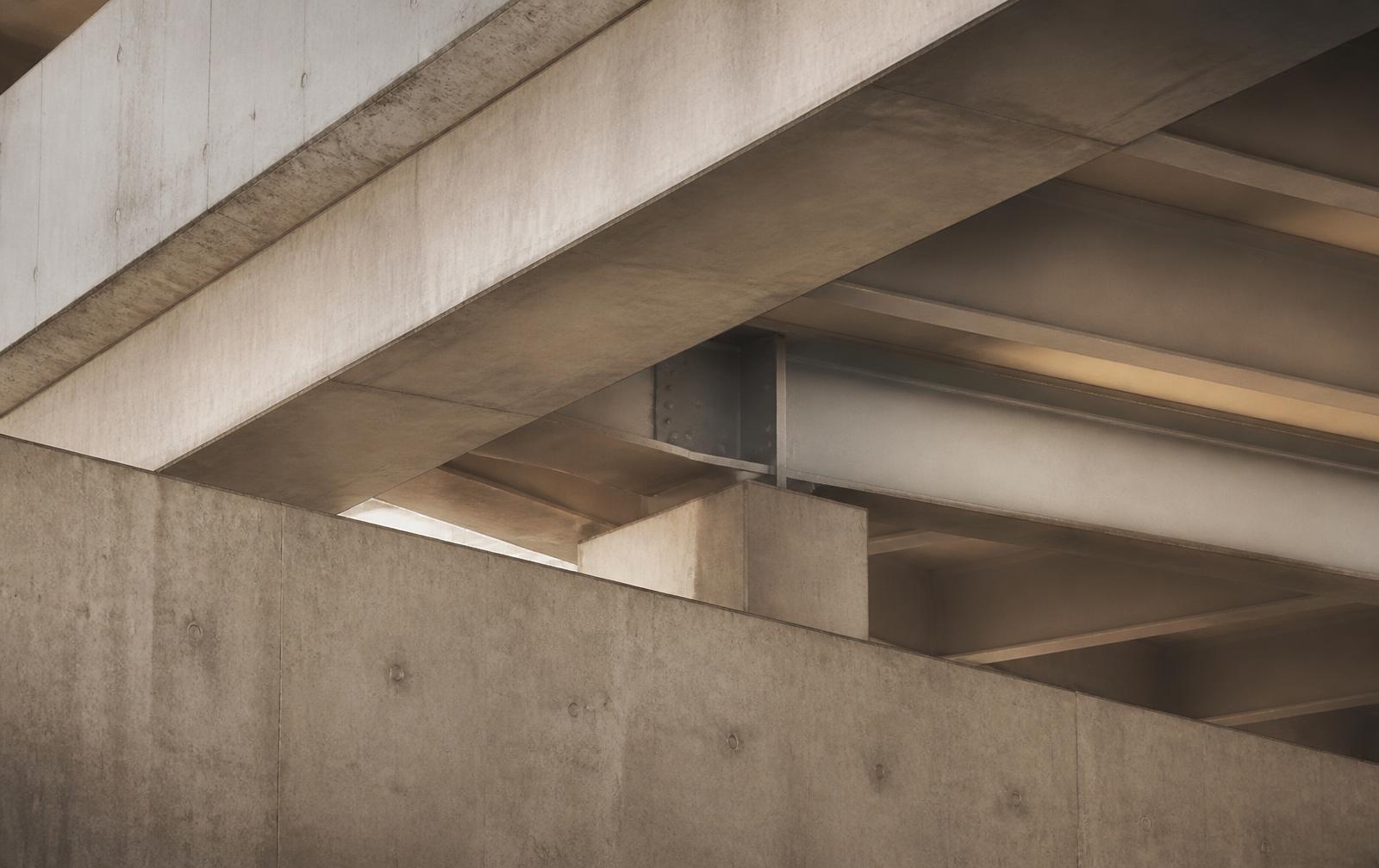 Layered concrete and steel structural beams in soft daylight