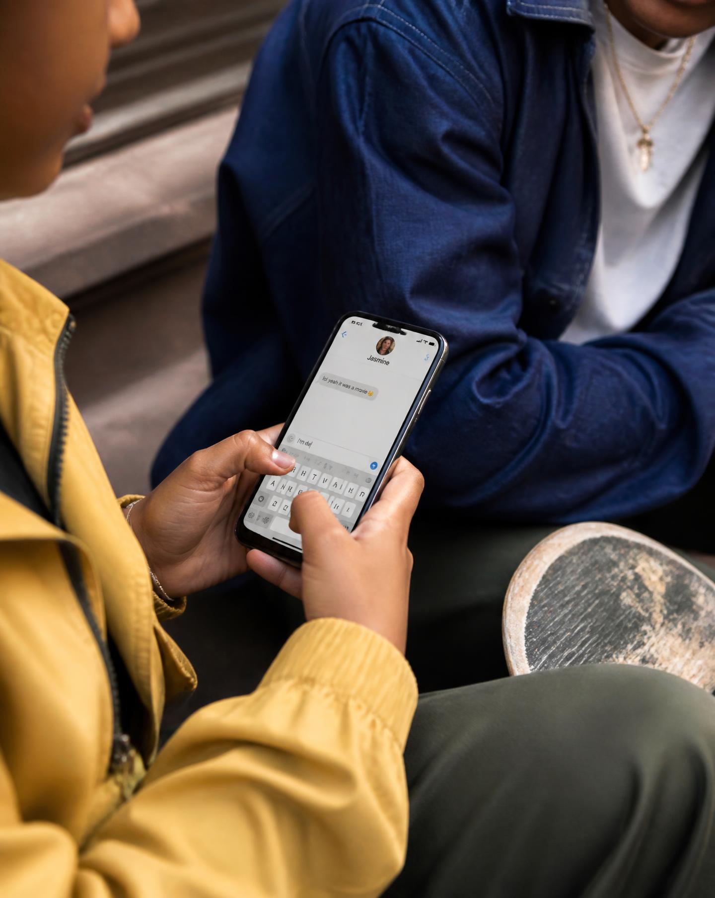 A hand holding a phone showing a check-in message to a friend