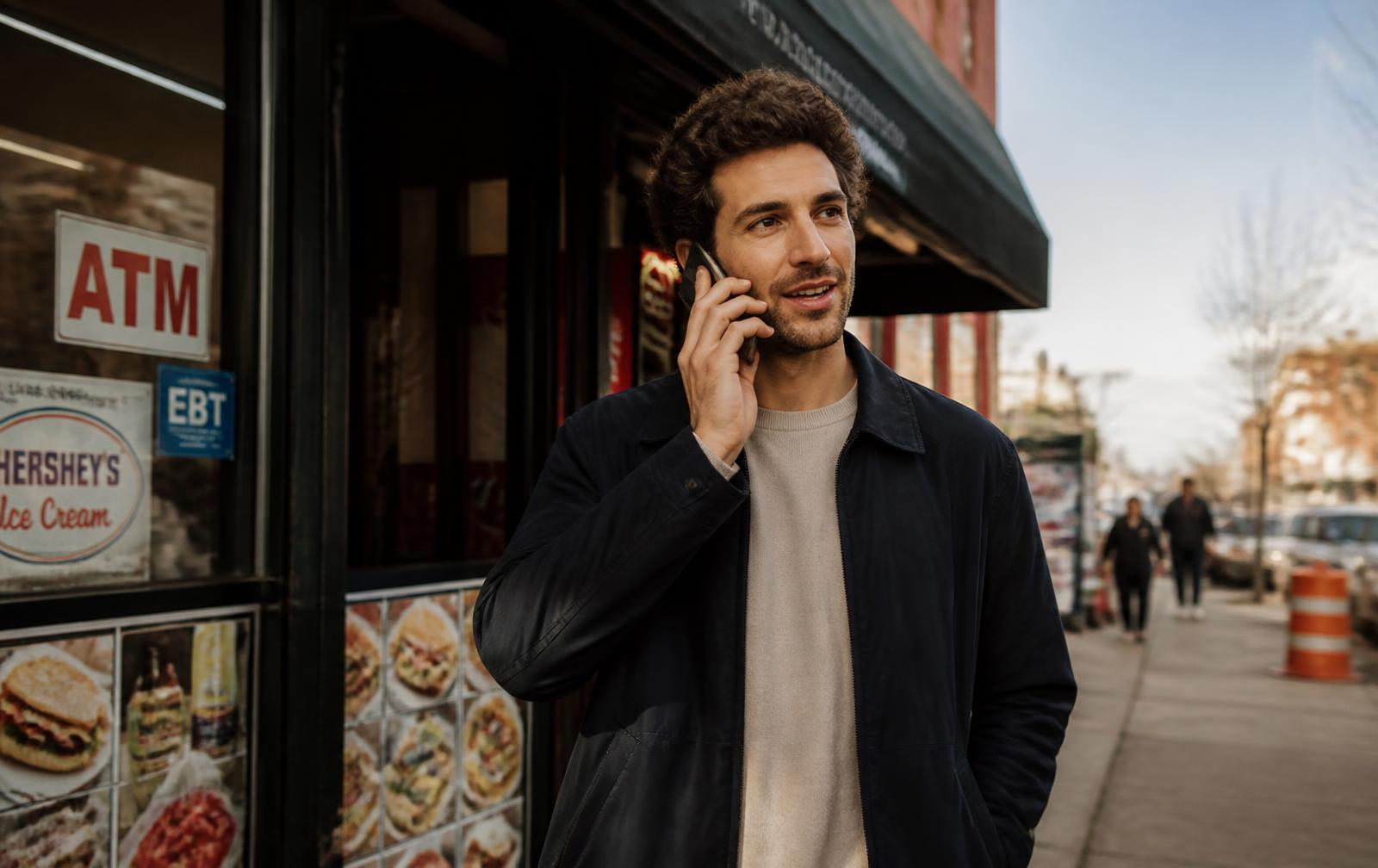 A man on a phone call outside, checking in on someone