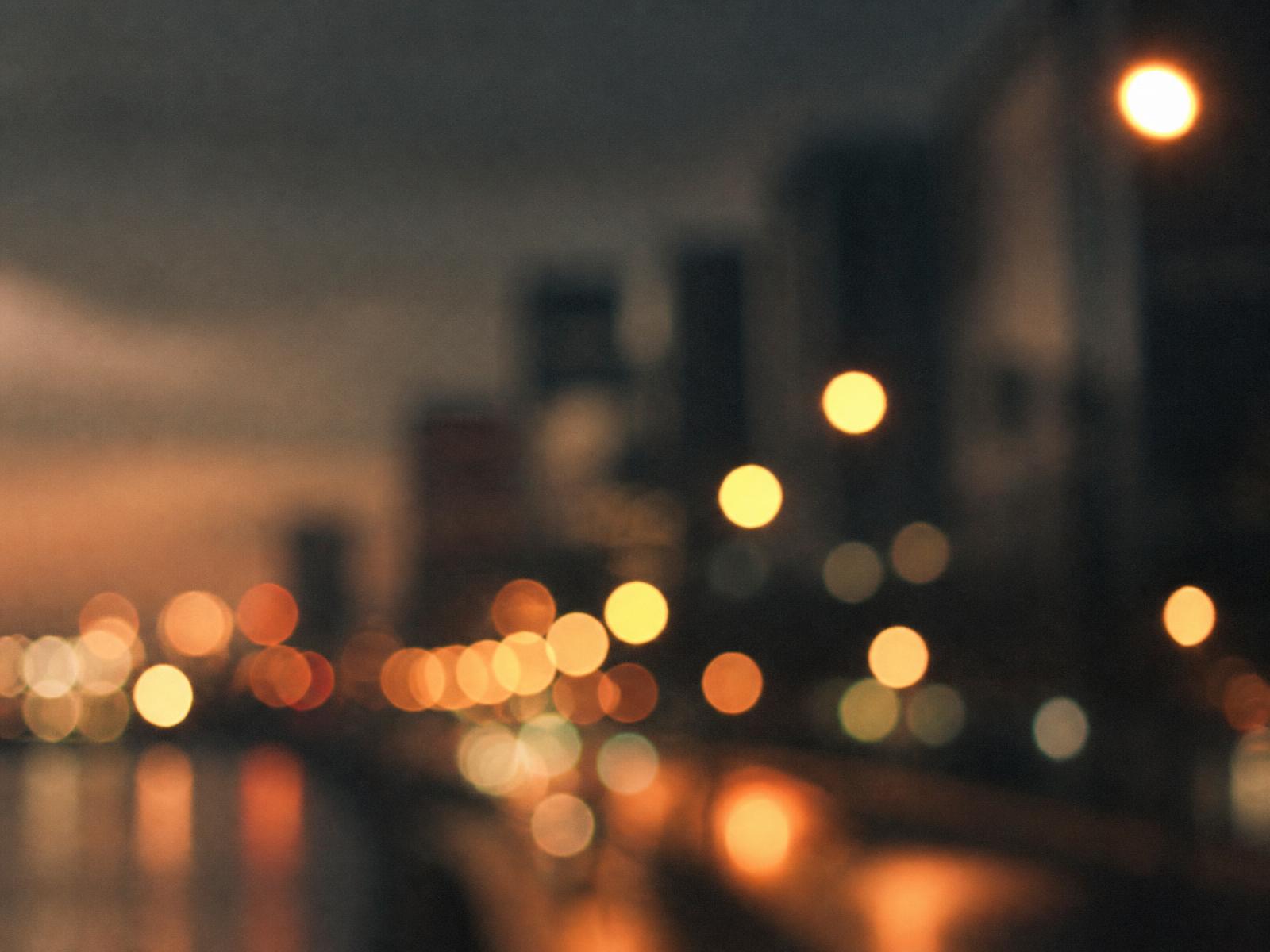Soft out-of-focus streetlights over a darkened cityscape at night