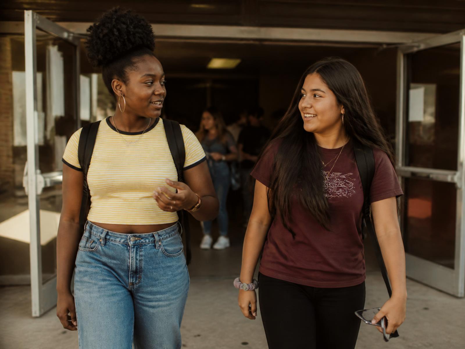 Diverse high school students walking together through a school corridor between classes